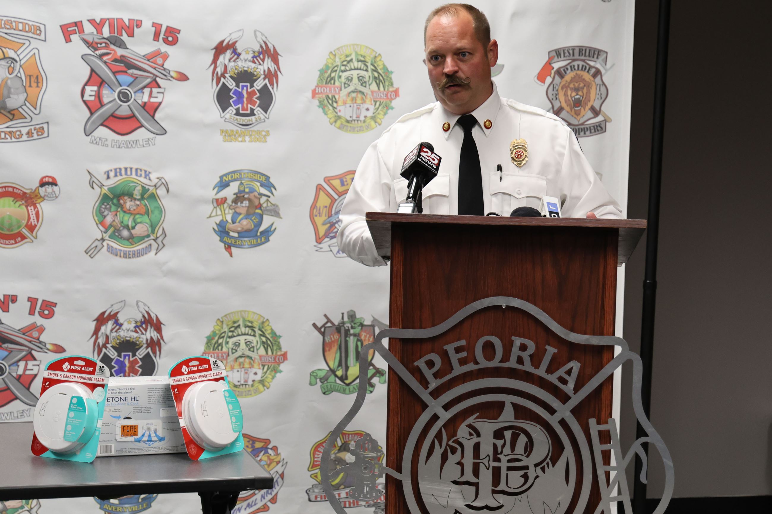 Photo of Peoria Fire Department Division Chief of Prevention Nate Rice stands behind a podium.