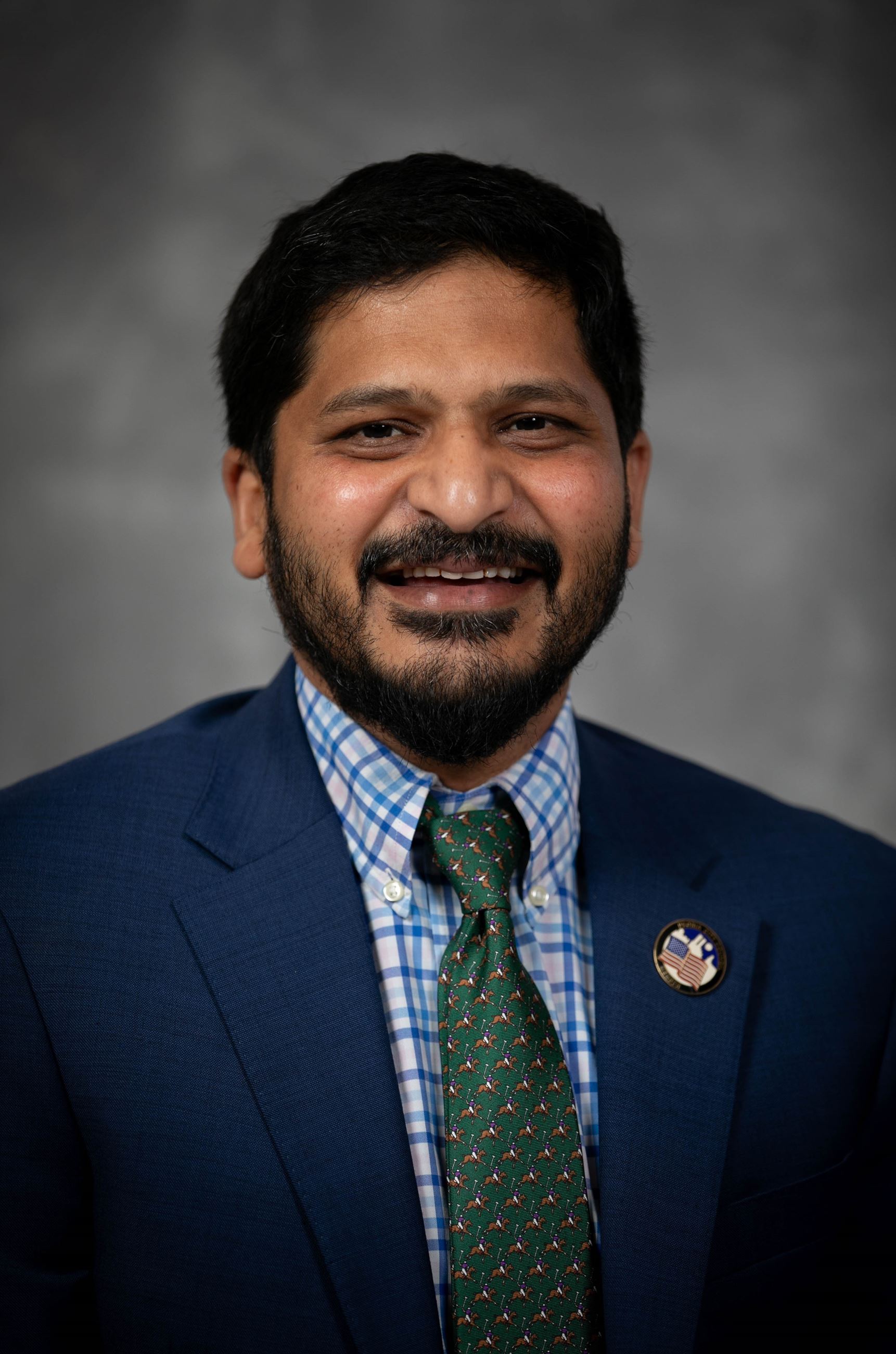 Headshot of a man in a coat and tie.